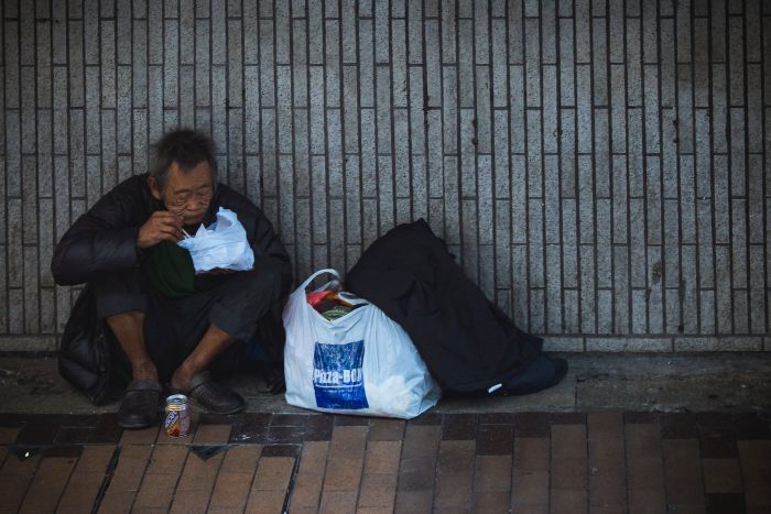 man sitting beside wall